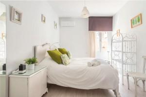 Dormitorio blanco con cama blanca y almohadas verdes en Wood&Stone Rooms en Yecla