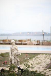 a statue of a woman sitting on the grass at Lavantalı Konak Otel Restoran in Seferihisar