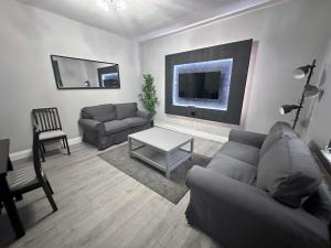 ein Wohnzimmer mit einem Sofa und einem Tisch in der Unterkunft Modernised 3 Bedroom House, Lascelle Residence in Roundhay