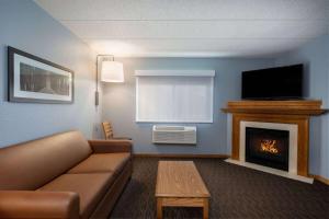 a living room with a couch and a fireplace at AmericInn by Wyndham Eau Claire in Eau Claire