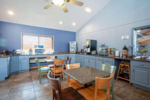 a kitchen with blue cabinets and a table and chairs at AmericInn by Wyndham Eau Claire in Eau Claire