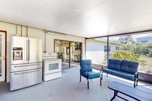 a kitchen with two blue chairs and a table at By the Beach - Full Property in Jacksonville