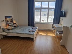 een slaapkamer met een bed, een bureau en een raam bij Zimmervermietung Berlin Mertens in Berlijn