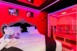 een slaapkamer met een bed met een rode muur bij L'Interdit Suite de Luxe in Serrières
