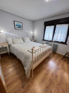 1 dormitorio con cama blanca y suelo de madera en Casa Boni y Florina en Nava