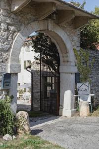 uma entrada para um edifício de pedra com uma porta arqueada em La Casetta in Valpolicella em Monte