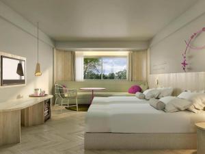 Mercure Rayong Lomtalay Villas & Resort في ماي بيم: غرفة نوم كبيرة بسريرين وطاولة