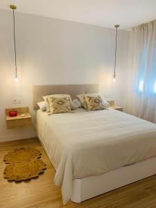 ein Schlafzimmer mit einem großen weißen Bett mit zwei Kissen in der Unterkunft Casa Carmela Fuengirola in Fuengirola