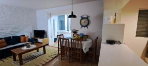 een keuken en een woonkamer met een tafel en een klok bij SUNNY House in Tirana