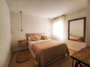 a bedroom with a bed with a mirror and a table at Casa Carmela Fuengirola in Fuengirola