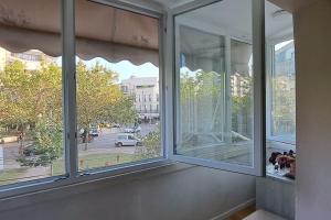 een kamer met een raam met uitzicht op een straat bij SUNNY House in Tirana
