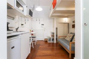 Una cocina y una sala de estar con un sofá. en Santos Tiny Studio by Homing, en Lisboa