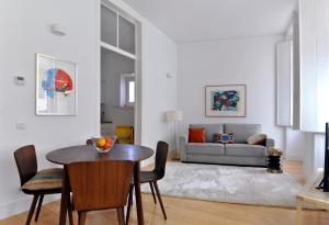 a living room with a table and chairs and a couch at Alfama Deluxe by Homing in Lisbon