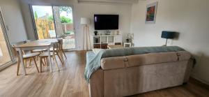 1 dormitorio con cama, mesa y comedor en LesOyats33 - Maisonnette avec Piscine, en Arès