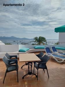ポルト・ダ・ポリェンサにあるApartamentos Torre Playaのバルコニー(椅子、テーブル付)