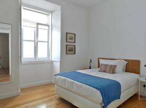 a white bedroom with a bed and a window at Alfama Prime Apartments by Homing in Lisbon