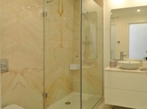 a bathroom with a glass shower with a sink at Alfama Prime Apartments by Homing in Lisbon +14 photos