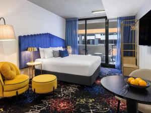 pokój hotelowy z łóżkiem i stołem w obiekcie Mercure Melbourne St Kilda Road w Melbourne
