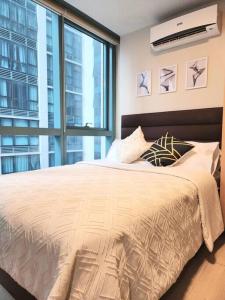 a bedroom with a bed and a large window at Cozy Comfy 1BR w/ Mall access Netflix Fast Wi-fi in Manila
