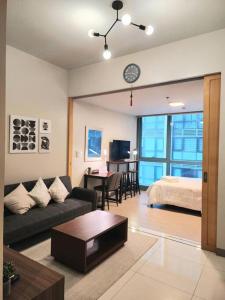 a living room with a couch and a bed at Cozy Comfy 1BR w/ Mall access Netflix Fast Wi-fi in Manila