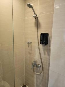 a shower with a glass door in a bathroom at Cozy Comfy 1BR w/ Mall access Netflix Fast Wi-fi in Manila