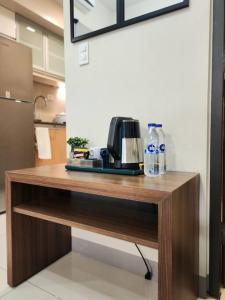 a wooden table with a coffee maker and water bottles on it at Cozy Comfy 1BR w/ Mall access Netflix Fast Wi-fi in Manila