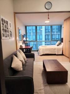 a living room with a couch and a bed at Cozy Comfy 1BR w/ Mall access Netflix Fast Wi-fi in Manila
