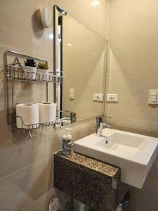 a bathroom with a sink and a mirror at Cozy Comfy 1BR w/ Mall access Netflix Fast Wi-fi in Manila