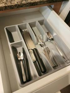 a drawer with silver utensils in a cabinet at Cozy Comfy 1BR w/ Mall access Netflix Fast Wi-fi in Manila