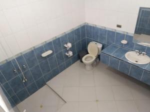 a blue tiled bathroom with a toilet and a sink at Finca Andalucia con Piscina en Mesitas in El Colegio