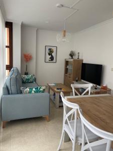 sala de estar con sofá y mesa de comedor en O Xaneiro, en Noia