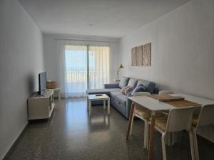 un soggiorno con divano e tavolo di BEACH VALENCIA 22 Apartment facing the sea with frontal views a Valencia