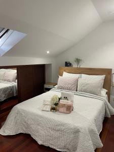 1 dormitorio con 1 cama grande con manta blanca en O Xaneiro, en Noia