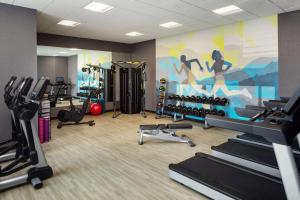 einem Fitnessraum mit Laufbändern und Trainingsgeräten sowie einem Wandbild in der Unterkunft Hyatt House Vacaville in Vacaville