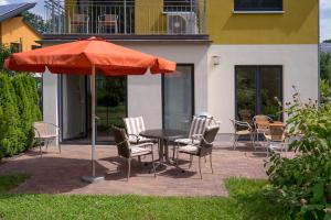 einen Tisch, Stühle und einen Regenschirm auf einer Terrasse in der Unterkunft Ferienpark Rübezahl in Berlin