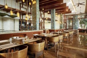 une salle à manger avec des tables et des chaises en bois dans l'établissement Sheraton Shenzhou Peninsula Resort, à Wanning