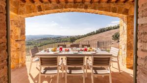 a dining room with a table and chairs on a patio at CASALE GROTTINI 8, Emma Villas in Manciano