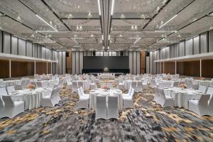 a banquet hall with white tables and white chairs at Renaissance Kuala Lumpur Hotel & Convention Centre in Kuala Lumpur
