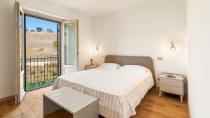 a white bedroom with a bed and a balcony at CASALE GROTTINI 8, Emma Villas in Manciano +53 photos