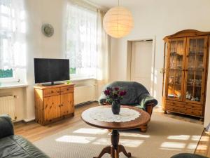 ein Wohnzimmer mit einem Tisch und einem TV in der Unterkunft Ferienwohnung Alte Dorfschule in Lüssow