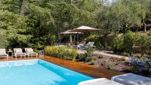 a swimming pool with a table and chairs and an umbrella at VILLA ADISA 8, Emma Villas in Uzzano