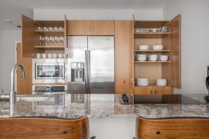 a kitchen with a stainless steel refrigerator and wooden cabinets at Streeterville 2br w lounge pool nr Riverwalk CHI-1003 in Chicago