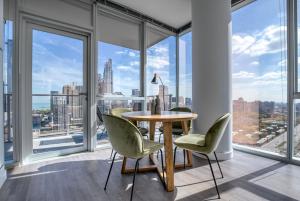 - une salle à manger avec une table, des chaises et de grandes fenêtres dans l'établissement South Loop 2br w pool gym rooftop nr L CHI-995, à Chicago