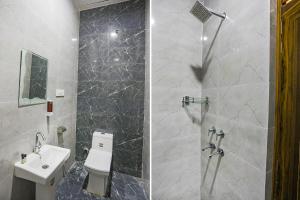 y baño con ducha, aseo y lavamanos. en FabHotel Moon Gaze Inn, en Kānpur