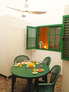 a green table with chairs and a plate of food on it at Bonita casa cerca de la playa - Chalet Eras Costeras in Las Eras