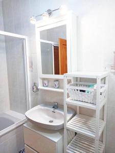 Baño blanco con lavabo y espejo en Bonita casa cerca de la playa - Chalet Eras Costeras en Las Eras