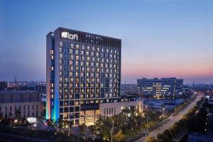 a lit up building in a city at night at Aloft Shanghai Zhangjiang Haike in Shanghai