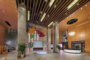 a lobby of a building with a fireplace and ceiling at Aloft Shanghai Zhangjiang Haike in Shanghai