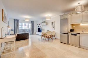 a kitchen and living room with a table and a refrigerator at Paraiso Palm Mar Precioso & luminoso apartamento reformado in Palm-Mar