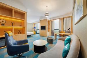 a hotel room with a couch and a chair at Aloft Shanghai Zhangjiang Haike in Shanghai